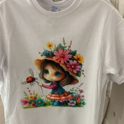 T-shirt branca com estampa de menina com flores e joaninha