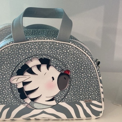 Mala infantil cinzenta com padrão de estrelas, aplicação de zebra e padrão zebra preto e branco na base.