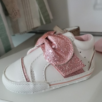 Tênis branco de criança com laço rosa brilhante