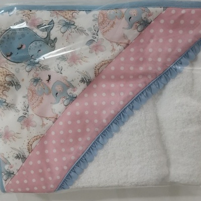 Toalha de banho para bebé com padrão colorido de baleias e flores, borda rosa com bolinhas e azul ondulada