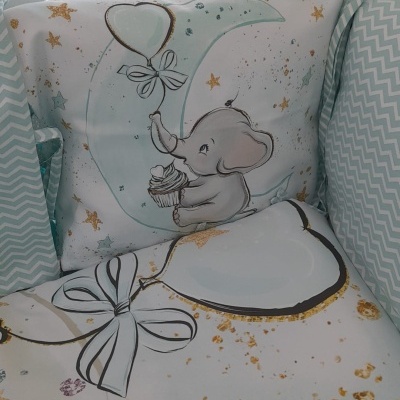 Almofada e roupa de cama infantil com elefante, lua, estrelas douradas e corações com laços em fundo branco