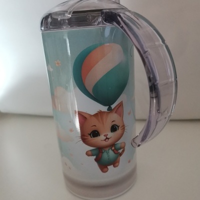 Copo infantil transparente com tampa e pega em plástico transparente com imagem de gato e balão