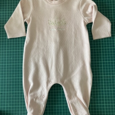 Macacão de bebé rosa claro com pequenos pontos brancos e bordado de coroa