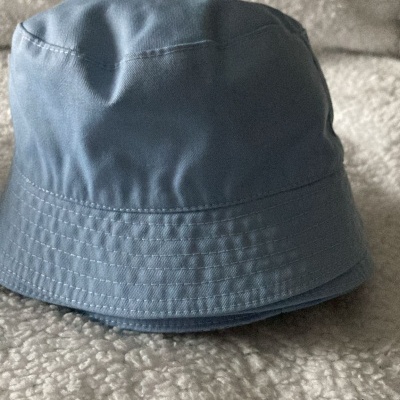 Chapéu tipo balde azul claro sobre tecido felpudo creme