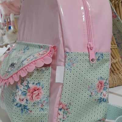 mochila infantil rosa e verde com padrão de flores cor-de-rosa e folhas azuis