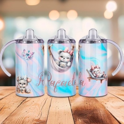 Três copos infantis com tampa e bico, padrão azul e rosa, ursinhos cinzentos com laço rosa e texto decorativo.