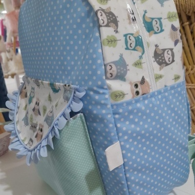 Mochila azul com bolinhas brancas e estampa de corujas, bolso verde claro com folho azul