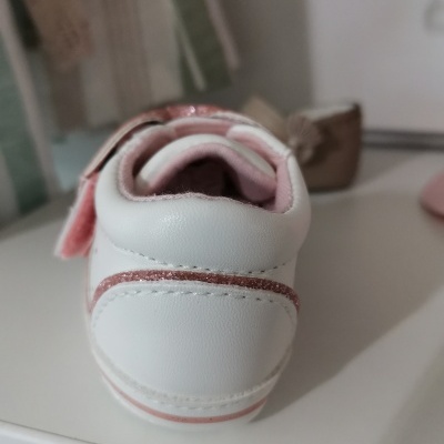 Tênis branco com detalhes rosa claro e interior cor de rosa visto de trás.