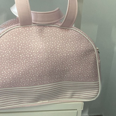 Bolsa pequena cor-de-rosa com pontos brancos e riscas horizontais