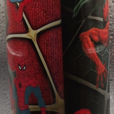 Copo com imagens do Homem-Aranha em várias poses sobre fundo preto com padrão de teia de aranha.