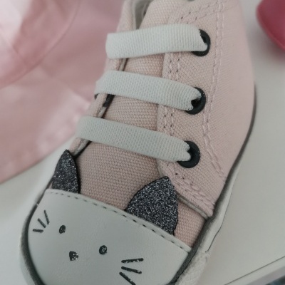 Tênis infantil rosa claro com rosto de gato no bico e cadarços brancos