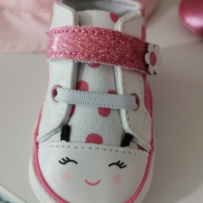 Sapato infantil branco e rosa com rosto sorridente desenhado no bico.