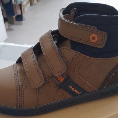 Bota infantil castanha com fechos de velcro em espaço interior