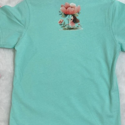 Camiseta azul clara para criança com estampa de flor e personagem nas costas