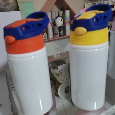 Dois bidons de plástico com tampas coloridas sobre balcão de vidro.