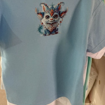 T-shirt azul clara com estampa de personagem fantástico colorido