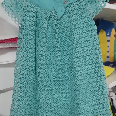 Vestido de bebé azul turquesa com renda e laço decorativo