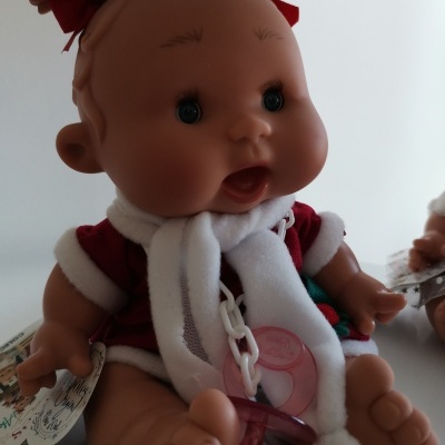 Boneca de bebé vestida de vermelho e branco com chupeta rosa