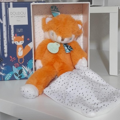 Pelúcia laranja de raposa com cobertor em caixa ilustrada