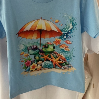 T-shirt azul claro com estampa de tartarugas na praia