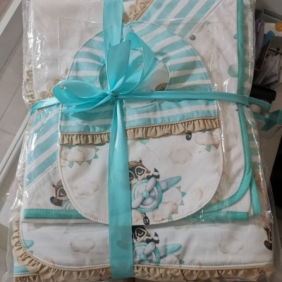 Conjunto de roupa de bebé azul e bege com padrões de aviões e corujas