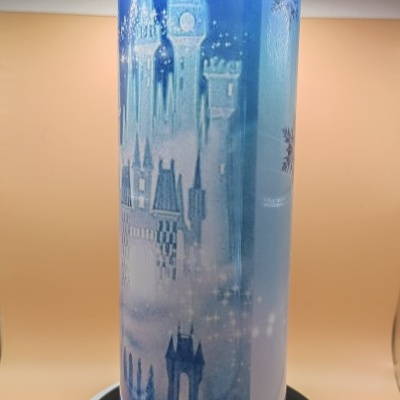 Copo azul com padrão de castelo e detalhes brilhantes.