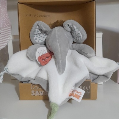 Boneco elefante de pelúcia cinzenta com manta branca e detalhes de bolinhas cinzentas