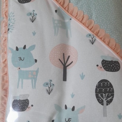 Manta de bebé com padrão de animais e árvores e acabamento rosa ondulado