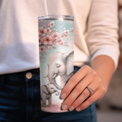 Copo térmico decorado com elefantes e flores cor-de-rosa na mão de uma pessoa