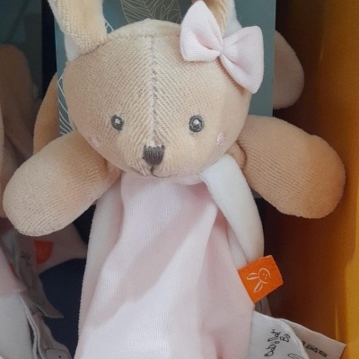 Pelúcia coelho bege e rosa claro com laço cor-de-rosa e etiquetas pendurada