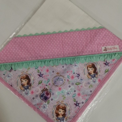 fralda branca com ponta triangular decorada com tecidos rosa, verde e personagens de desenho animado