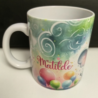 Caneca branca com desenho colorido com balões, nuvens e o nome Matilde