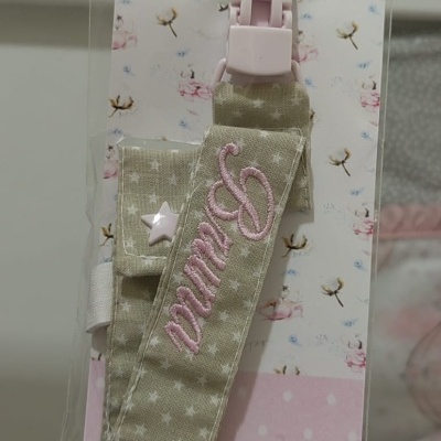 Prendedor de chupeta em tecido bege com estrelas e clip rosa na embalagem Baby Blush