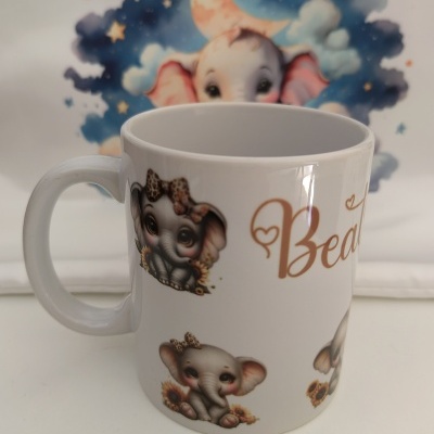 Caneca branca com elefantes bebés e texto 'Bea', pano decorativo com elefante e lua ao fundo