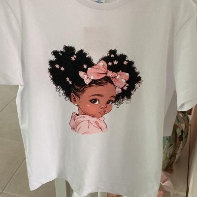 T-shirt branca com desenho de menina com cabelo cacheado e laço cor-de-rosa