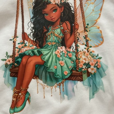 T-shirt branca com estampa de fada num balanço com vestido verde e flores.