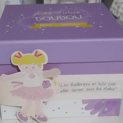 Caixa de cartão roxa e branca com ilustração de menina bailarina e texto em francês.