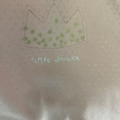 Tecido cor-de-rosa claro com pontos brilhantes verdes e coroa com texto little dancer