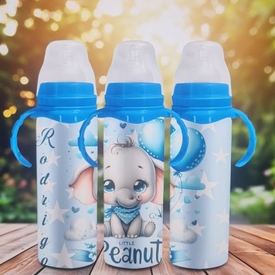 Três biberões azuis decorados com desenhos infantis em azul e branco sobre uma mesa de madeira