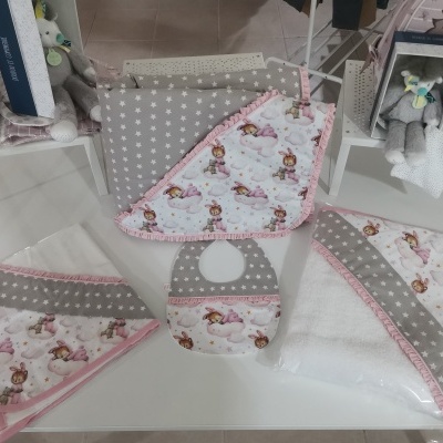 Conjunto têxtil para bebé com desenhos infantis e estrelas cinzentas em mesa branca