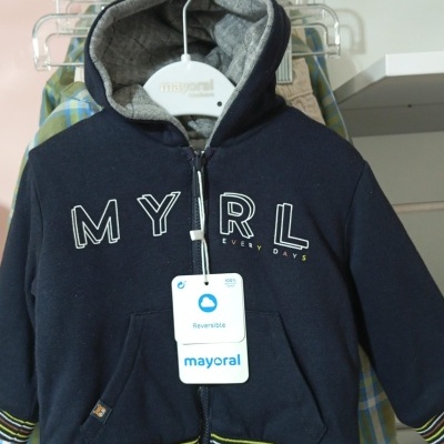 Sweatshirt azul escuro com capuz cinza acolchoado pendurada em cabide branco