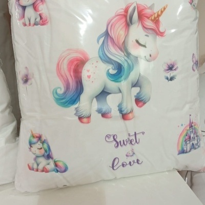 Almofada branca decorada com desenhos coloridos de unicórnios e texto Sweet love