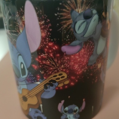 Caneca preta com personagens Stitch e fogos de artifício