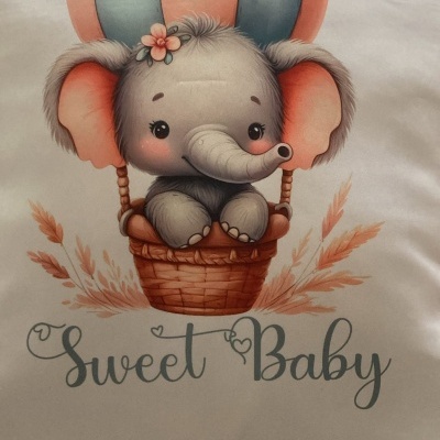 Almofada branca com desenho de elefante bebé num balão de ar quente e texto Sweet Baby