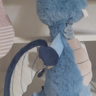 Pelúcia dragão azul com asas creme e etiqueta 'Welcome OURS'