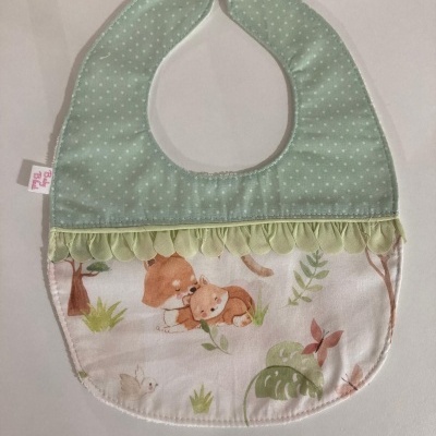 Babete para bebé com padrão de pontos e estampado de animais.