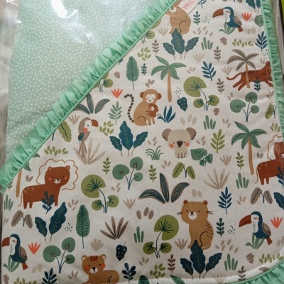 Manta para bebé com padrão de animais coloridos e borda verde