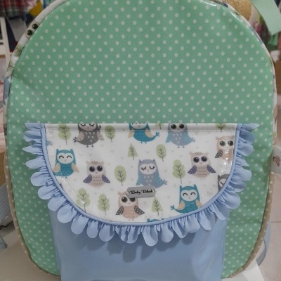 mochila com padrão de bolinhas verdes e bolso frontal azul com corujinhas
