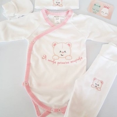 Conjunto de roupa de bebé branco com bordados de ursinho e detalhes em rosa.