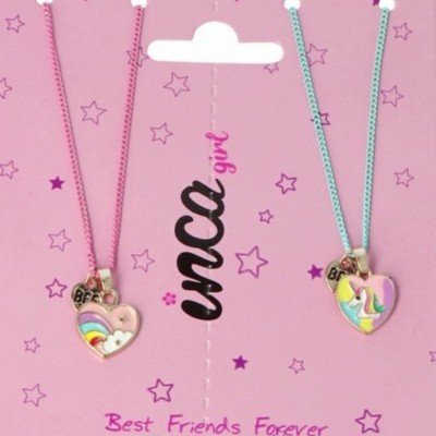 Dois colares coloridos com pendentes de coração e designs de unicórnio e arco-íris em fundo rosa decorado